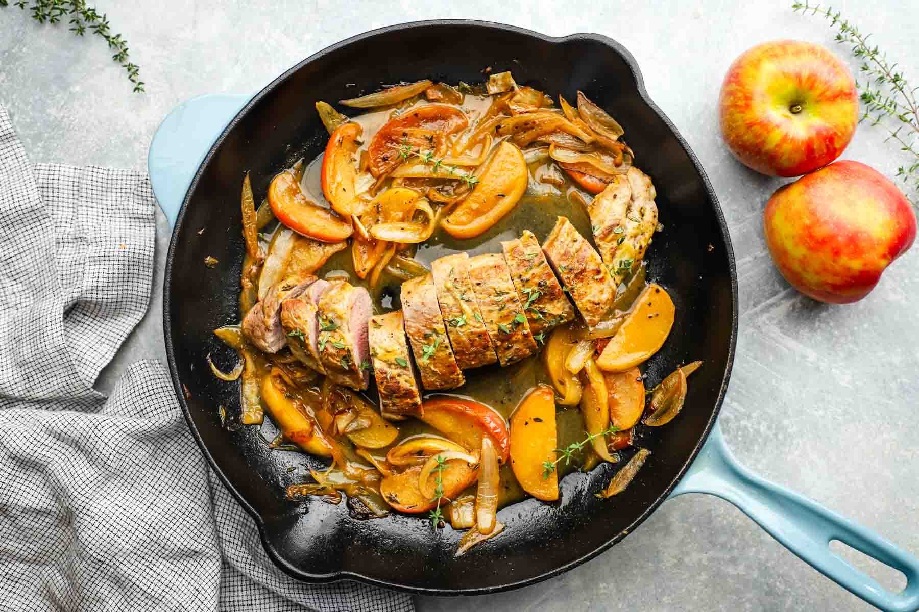 a skillet of pork tenderloin with apples and onions