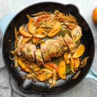 a pan with serving of pork tenderloin with apples and onions