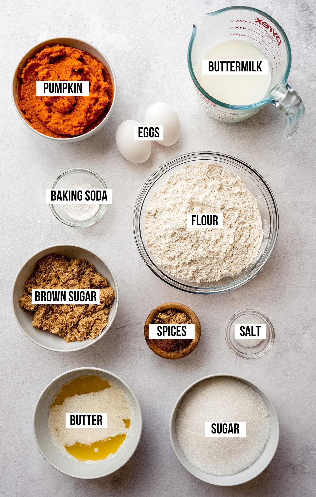 Aerial photo of ingredients to make pumpkin cake with text overlay labeling each ingredients.