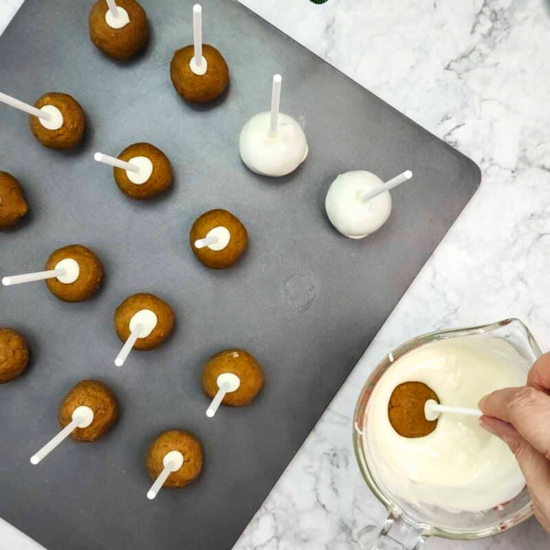 Overhead view of process shot 6 - melt the rest of the chocolate chips and dip each cake pop into the chocolate.