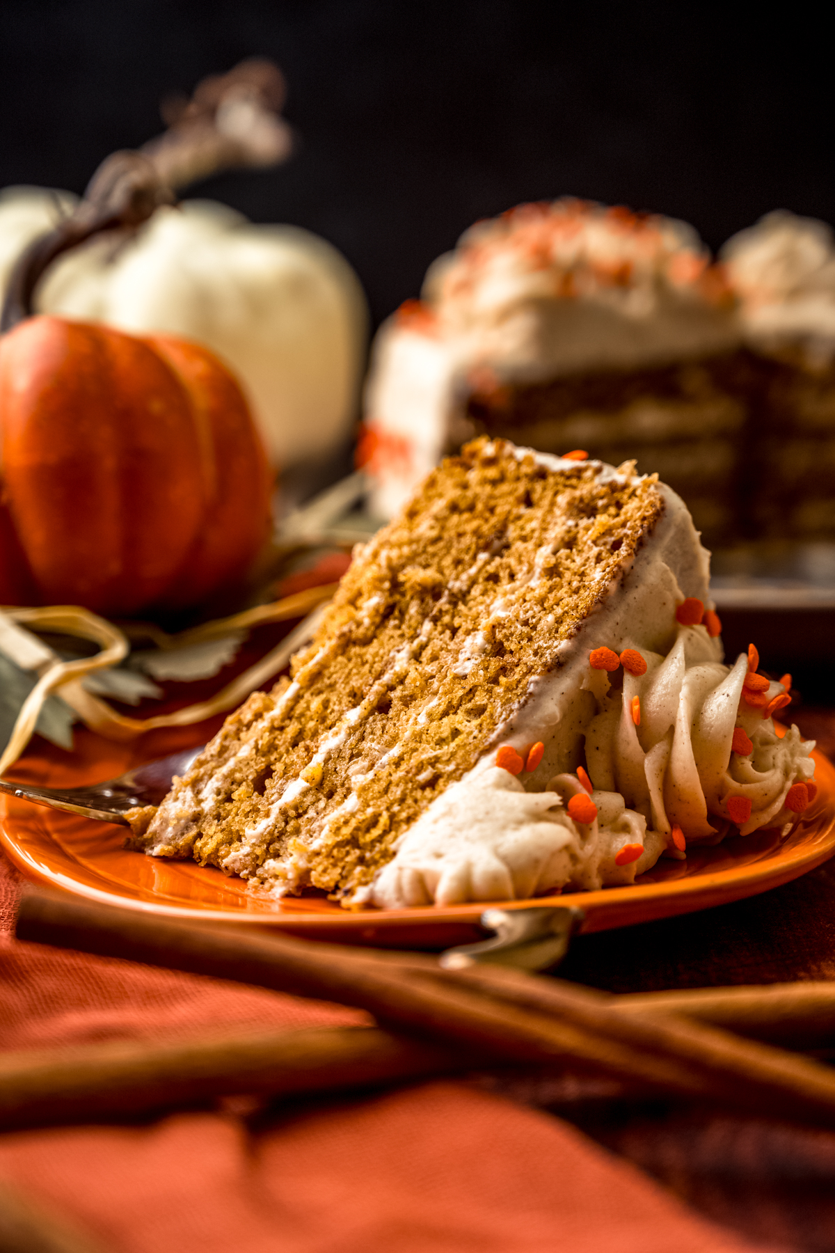 A slice of pumpkin layer cake on a plate with a fork.
