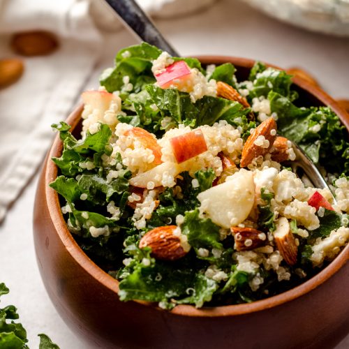 apple, quinoa, and almond kale salad in a bowl