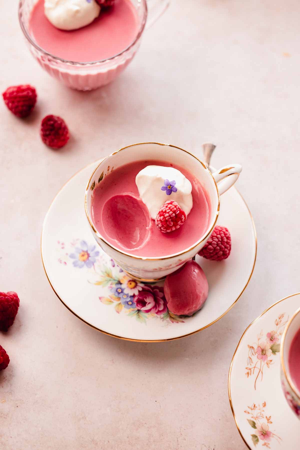 raspberry posset in teacup with small spoon