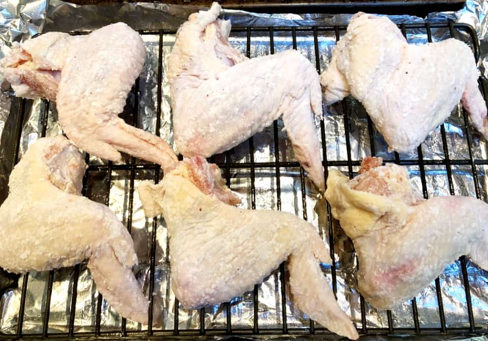 raw chicken wings on a rack before baking.