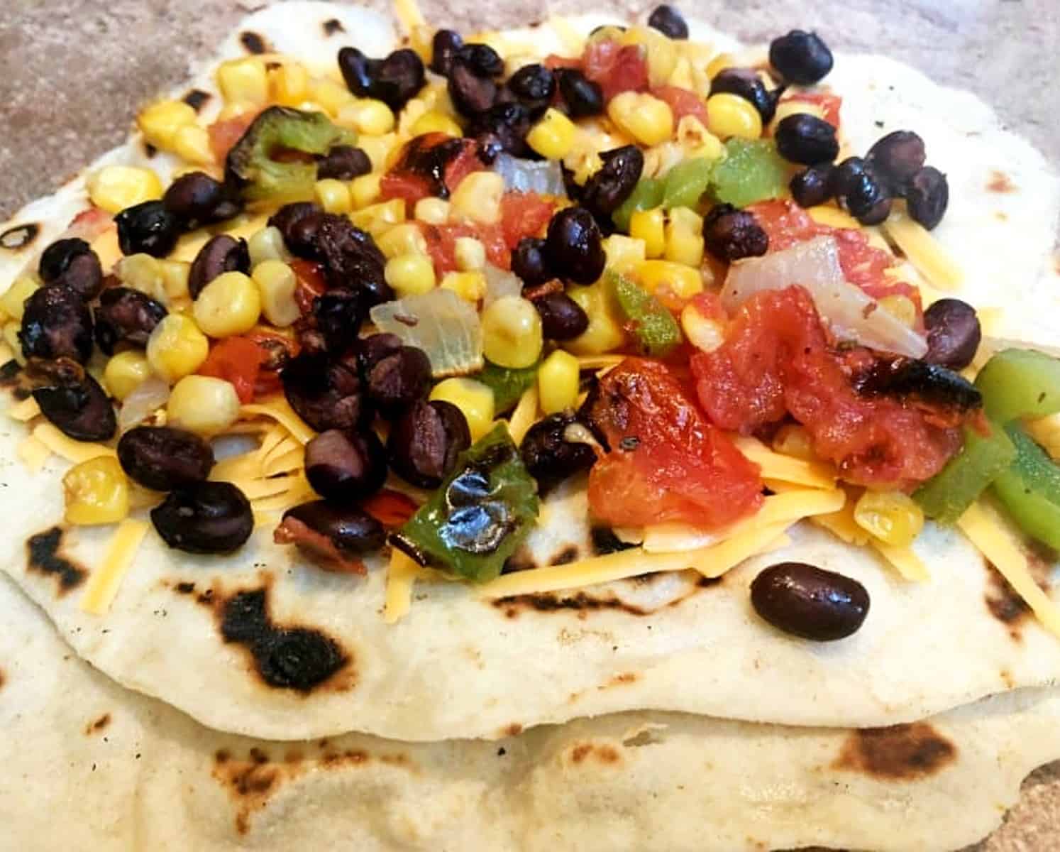 roasted vegetables on a quesadilla before cooking.