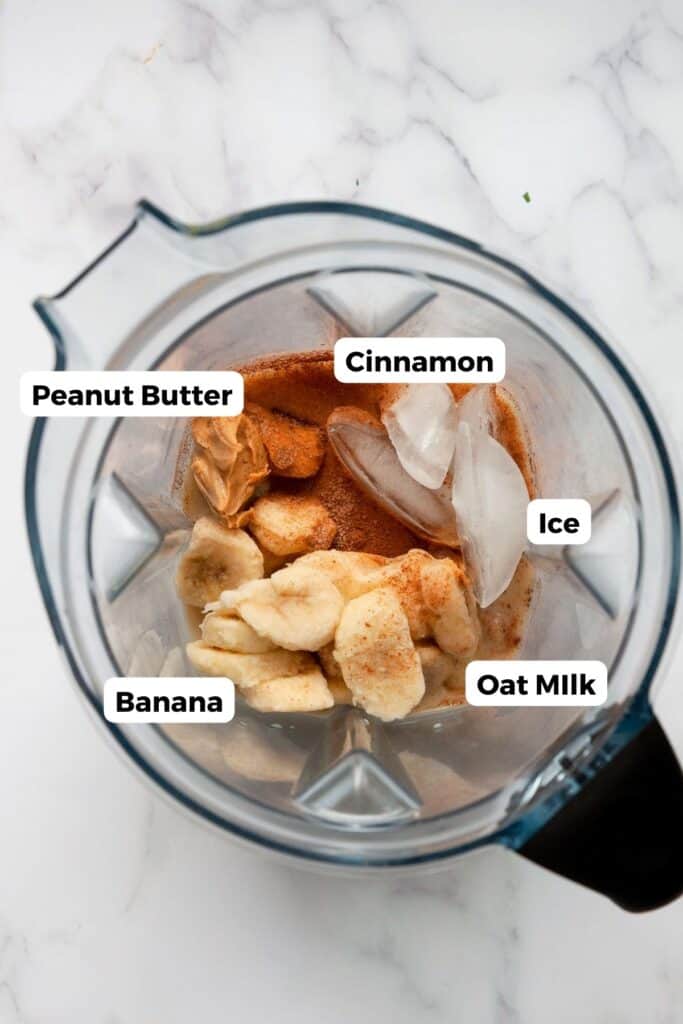 all ingredients in oat milk smoothie including oat milk, peanut butter, banana, cinnamon and ice