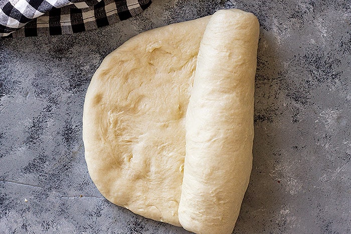 Shaping the dough to be placed in the bread pan.