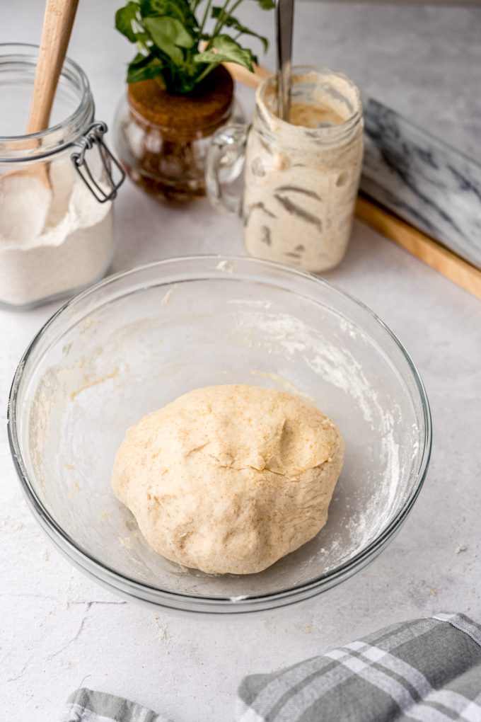 A bowl of sourdough cinnamon roll dough in a ball.