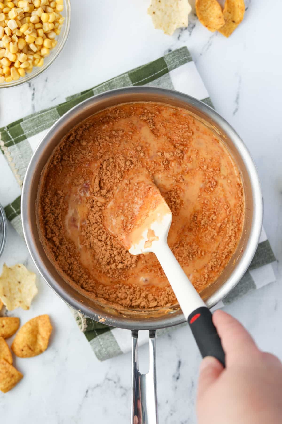Stirring taco seasoning into Rotel dip.