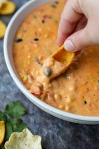 Dipping a corn chip into a velveeta based dip.