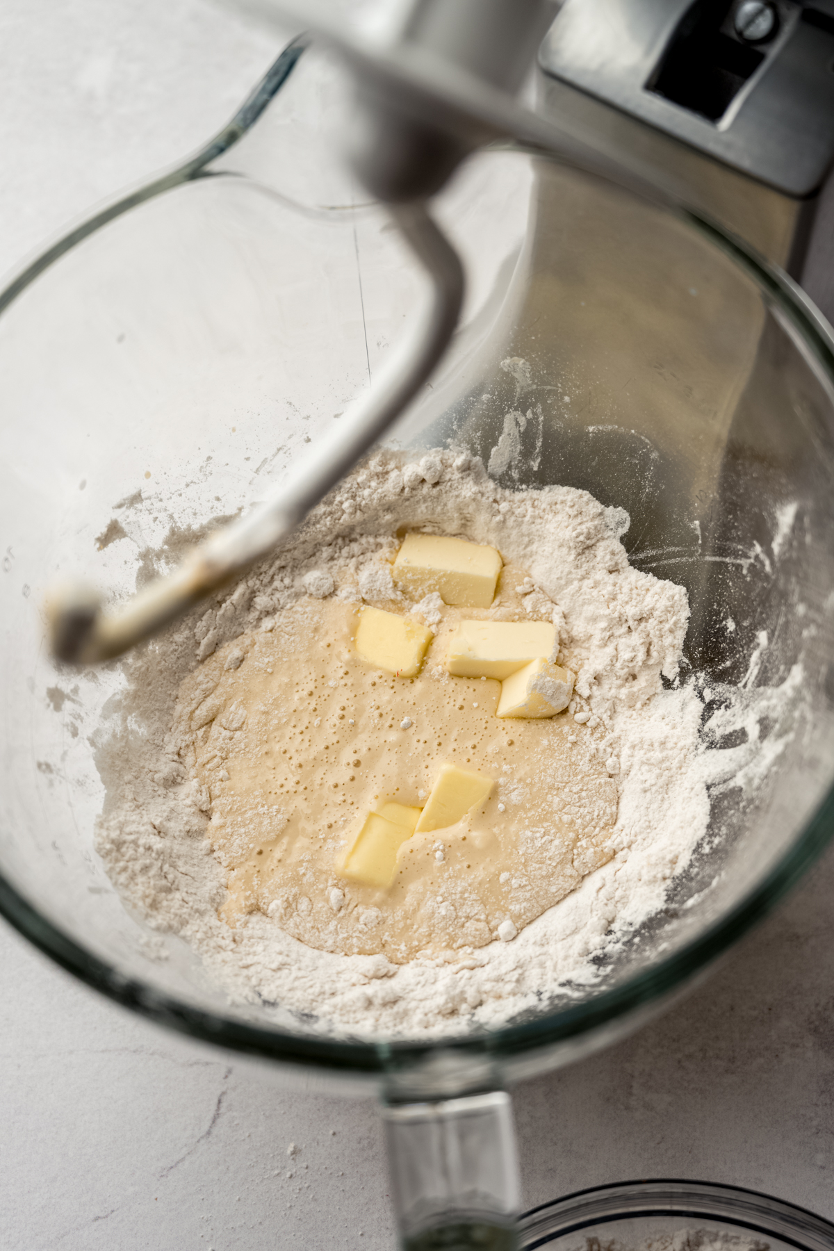 Yeast, flour, and butter in the bowl of a stand mixer ready to make yeast dough.