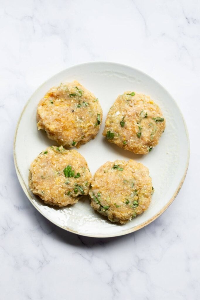 four raw chicken parm burger patties stuffed with mozzarella