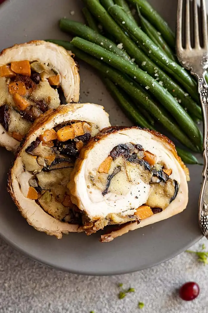 Overhead close up shot of slices of stuffed turkey breast. Showing all the sweet potatoes, stuffing, and dried cranberries!