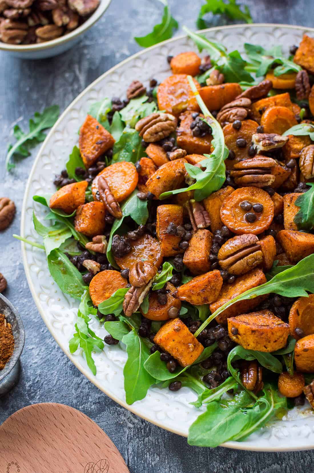 Side shot of roasted sweet potato, puy lentil, rocket (arugula) and pecan salad with pomegranate molasses dressing