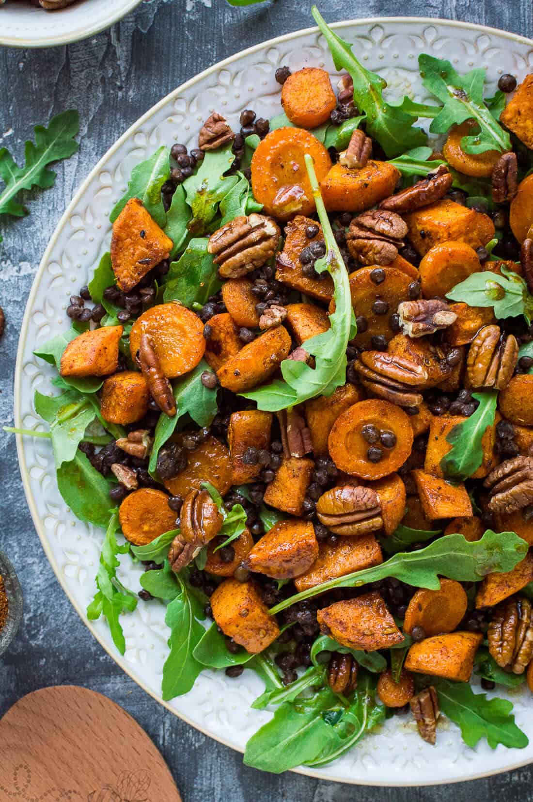 Roasted sweet potato, lentil and rocket salad – this hearty salad is filled with Ras el Hanout spiced roasted sweet potato and carrot, puy lentils, rocket  (arugula) and toasted pecans. #vegan #salad #healthy
