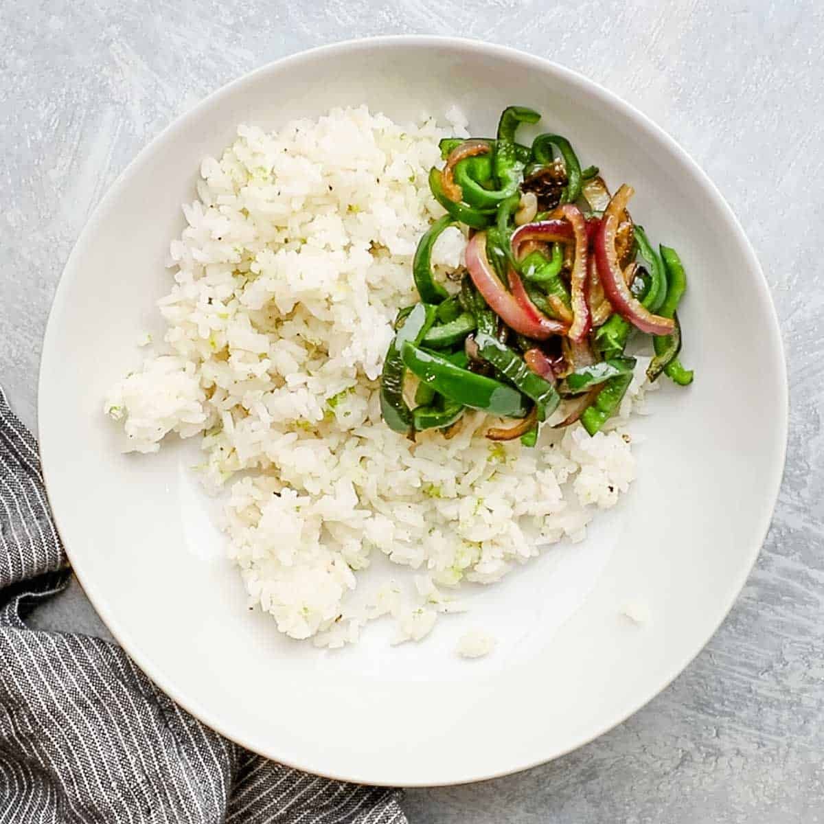 peppers and onions added to a bowl of rice
