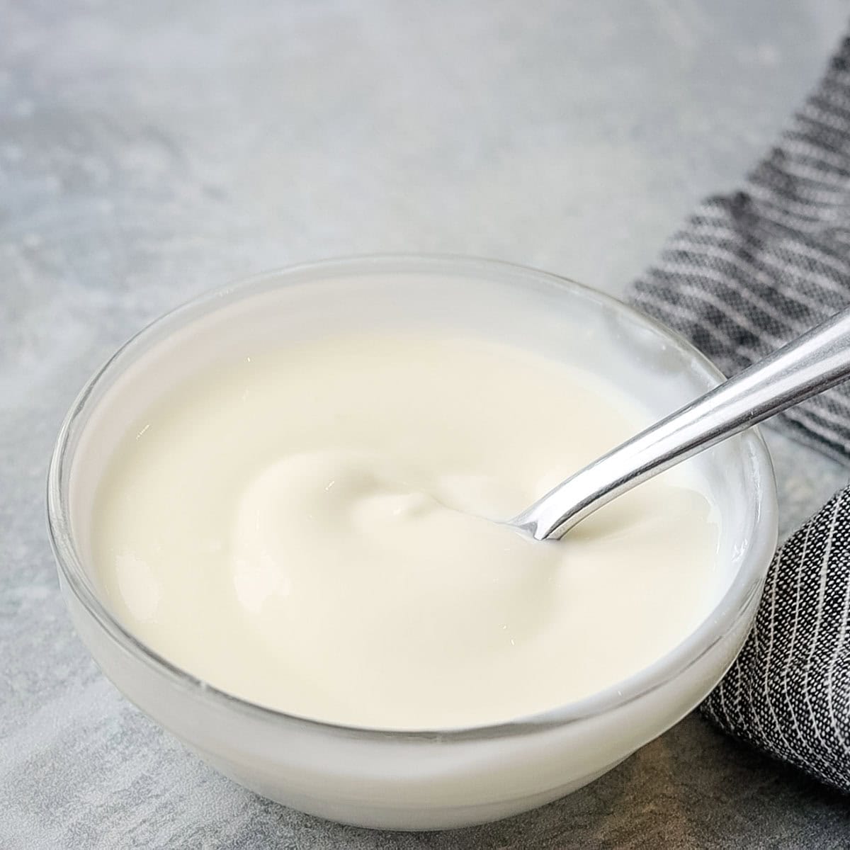 lime crema in a small bowl with a spoon in it