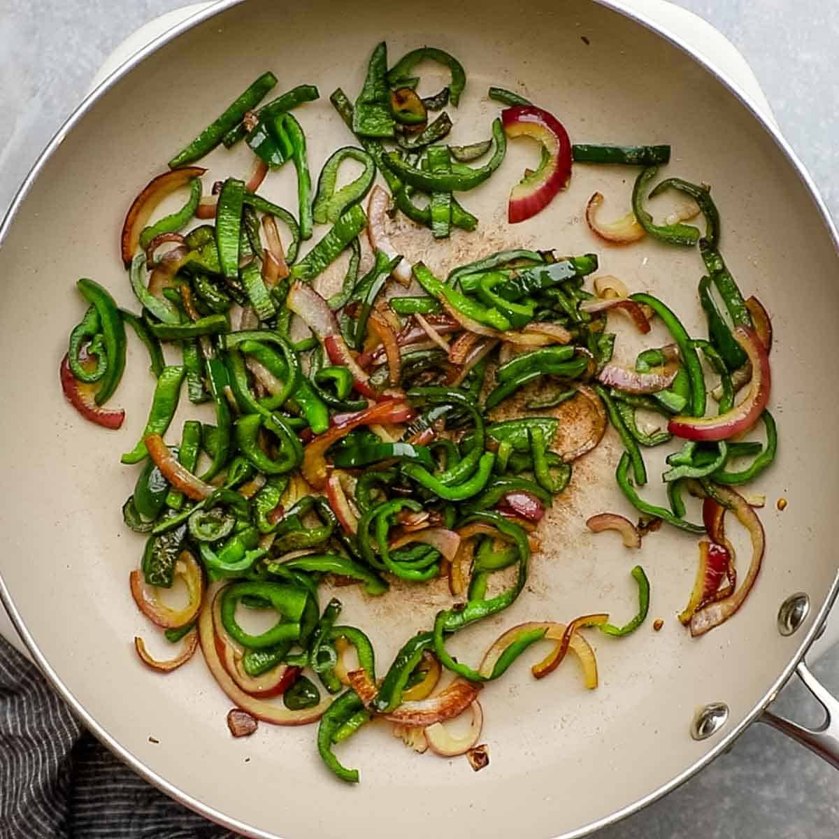 onions and peppers caramelized in a skillet