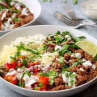 a rice bowl with ground beef, pico de gallo, sour cream, and cheese.