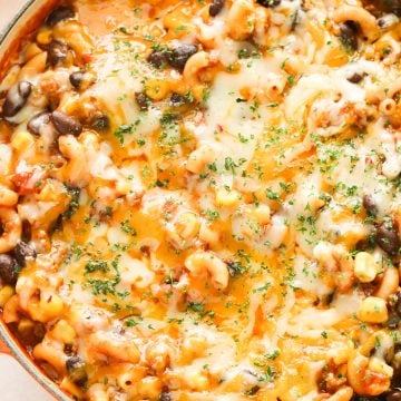 Macaroni pasta dish with black beans and melted cheese in a Dutch oven.