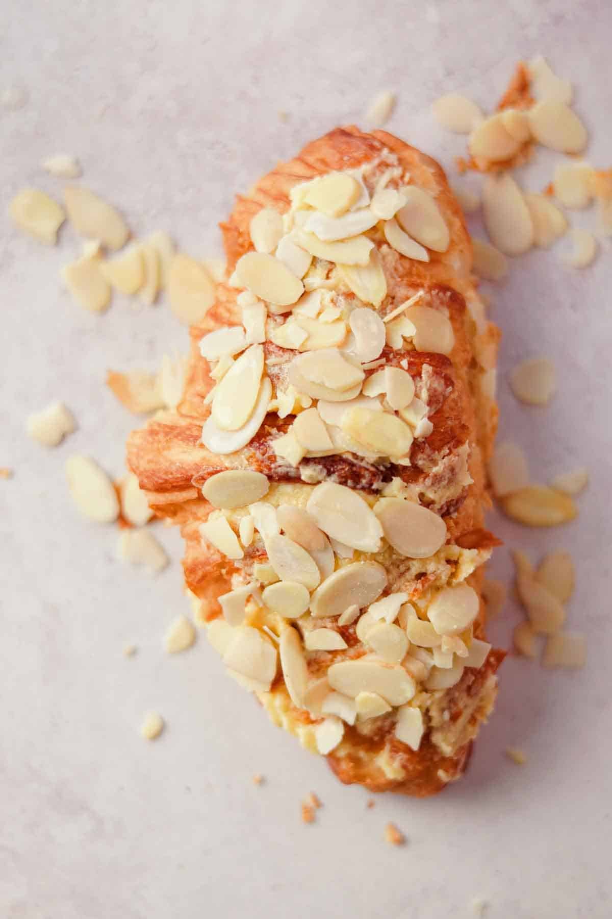 topping almond croissant with sliced almonds