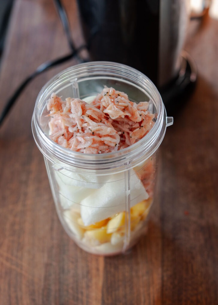 Savory ingredients and salted shrimp in a small blender.