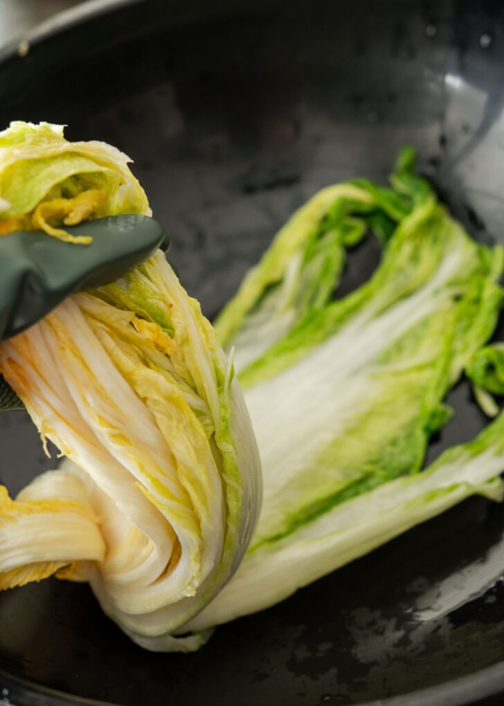Lifting up the cabbage getting ready for applying the kimchi seasoning paste.