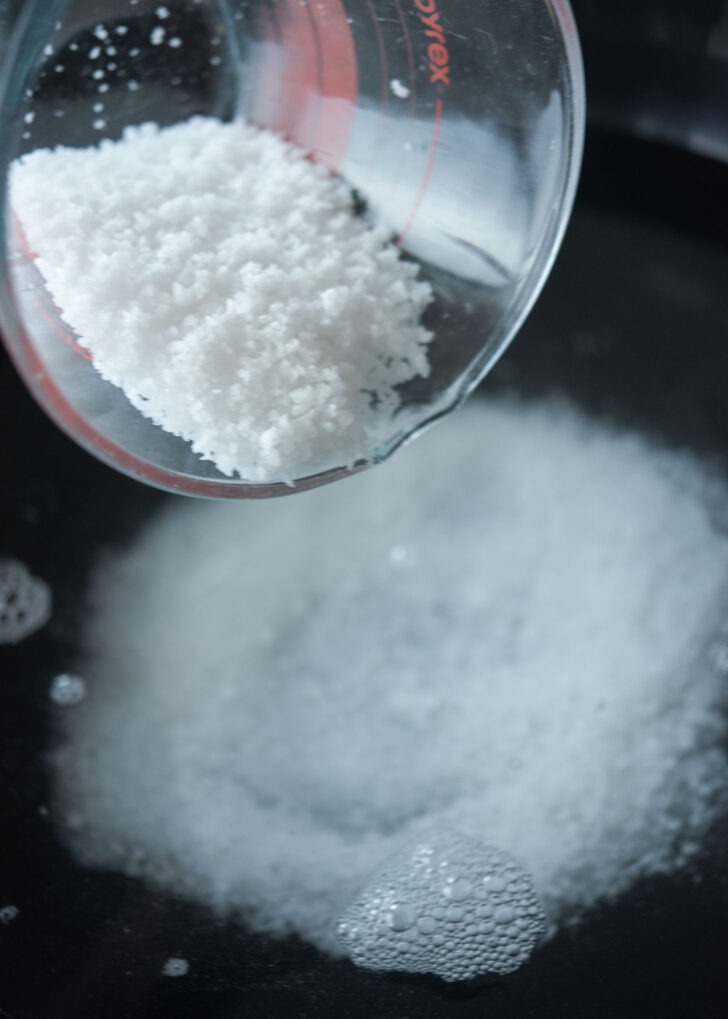 Adding salt to water to make salt brine.