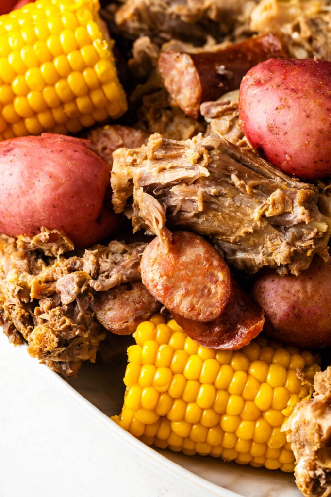 plate of cajun turkey neck boil with smoked sausage, potatoes and corn