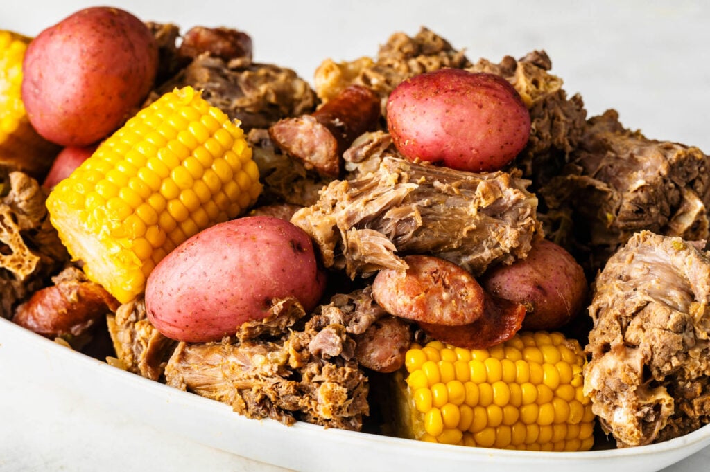 plate of cajun turkey neck boil with smoked sausage, potatoes and corn