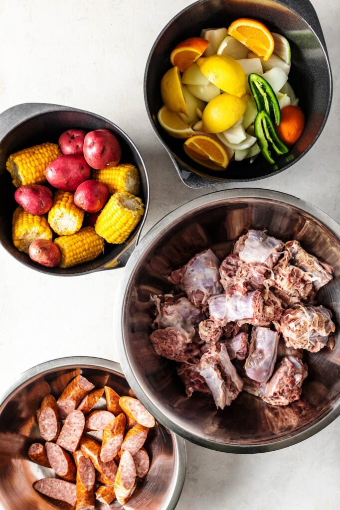 cajun turkey neck boil ingredients. lemons, onions, jalapenos, oragnes, red potatoes, corn nibblers, turkey necks, and smoked sausage