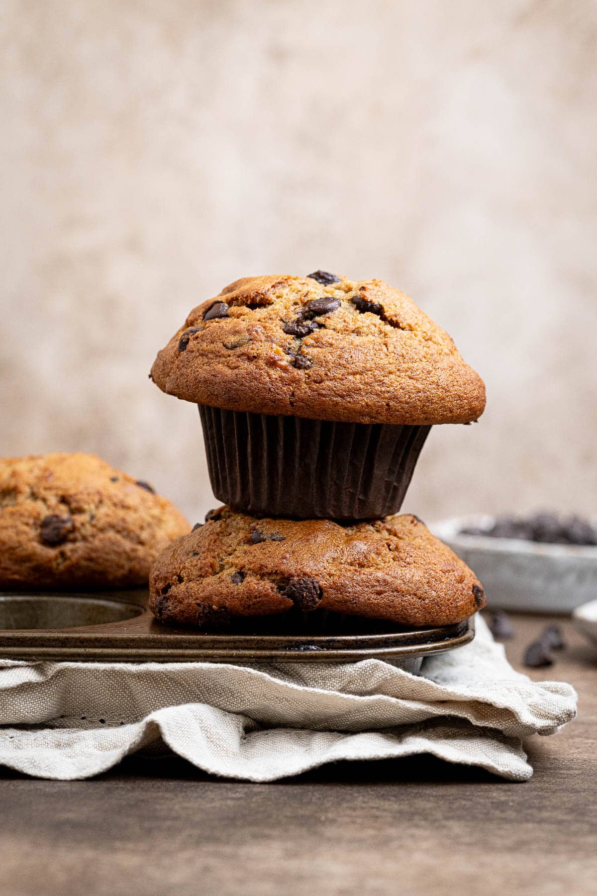A stack of two vegan banana muffins on a muffin pan.