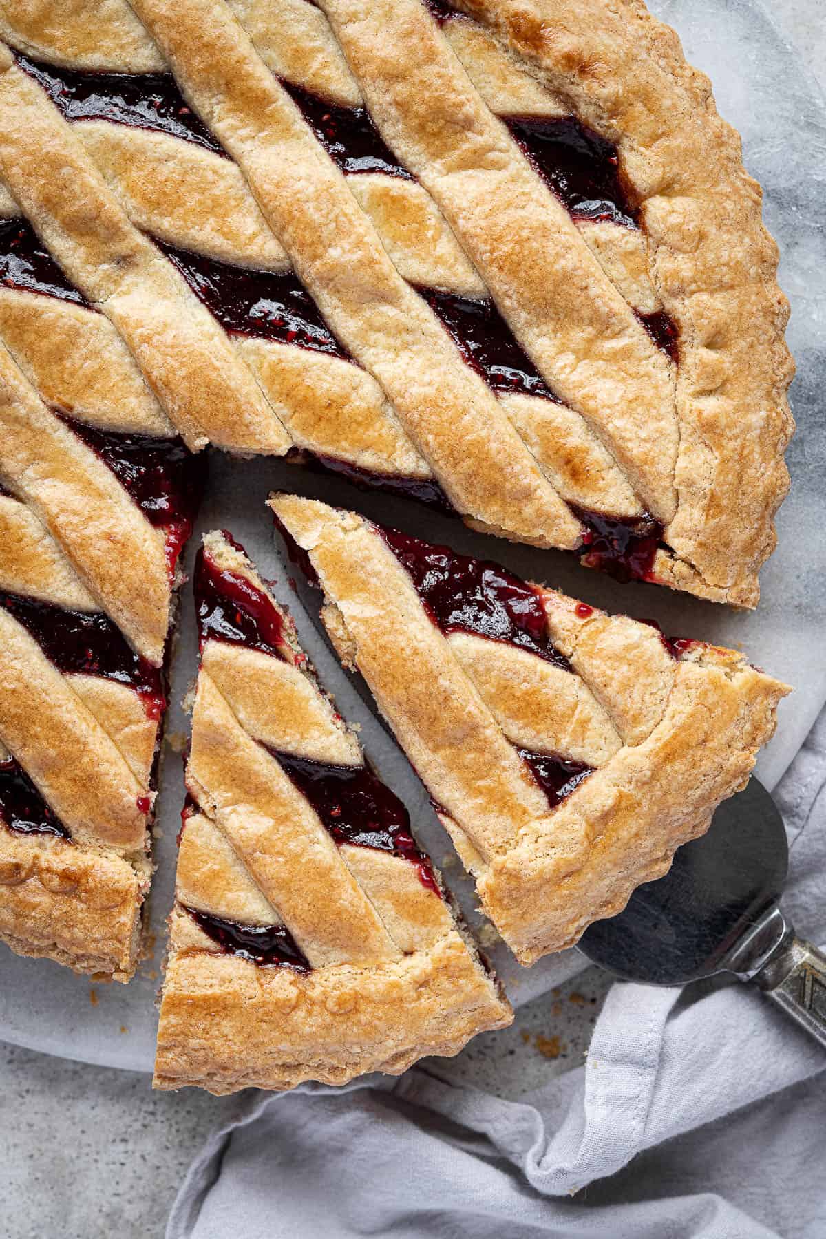 Close up of vegan crostata with two slices cut out.