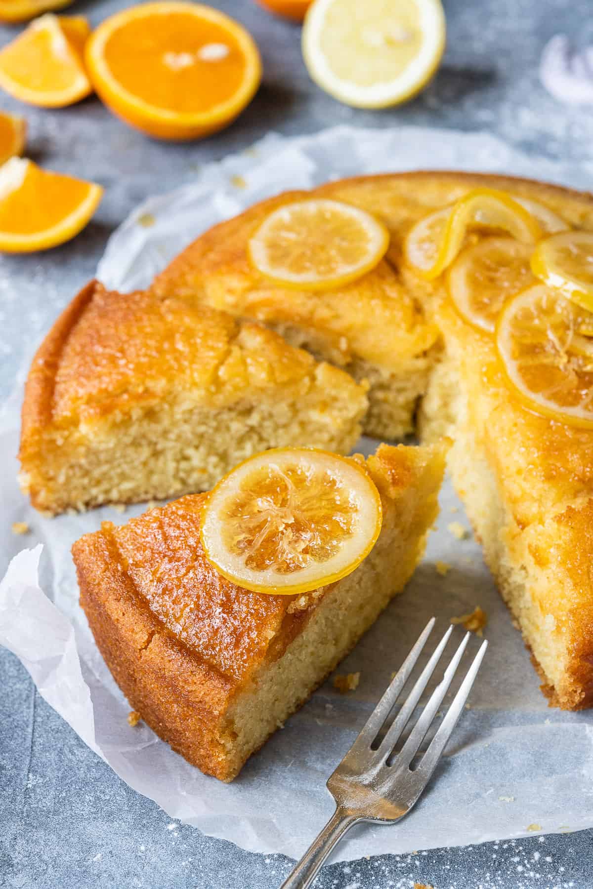 Close up of a slice of cake topped with a slice of candied lemon