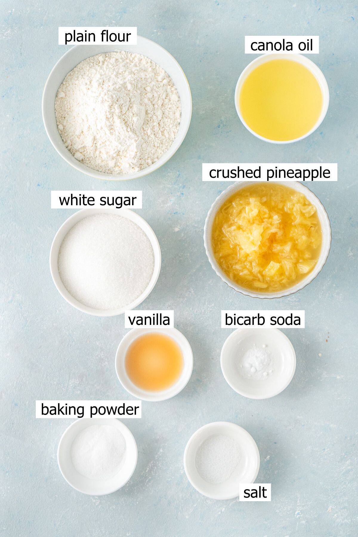 All ingredients needed to make vegan pineapple cupcakes laid out in small bowls.