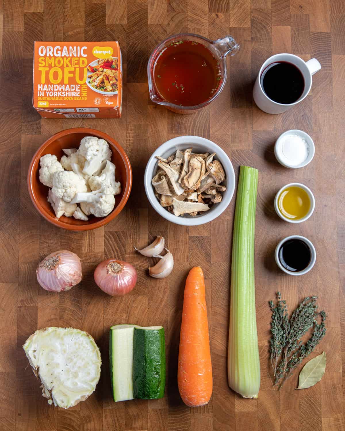 Photo of the ingredients for making this vegan stew recipe, all set on a wooden tabletop.