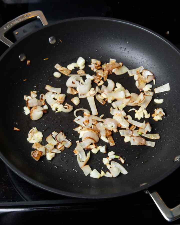 Photo of onions frying in a pan.