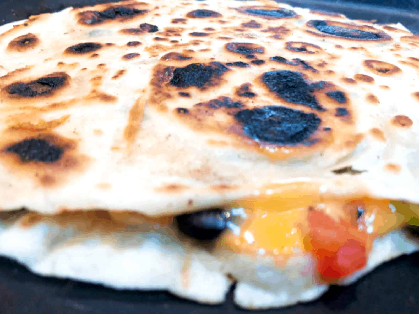 veggie quesadilla cooking in a pan.